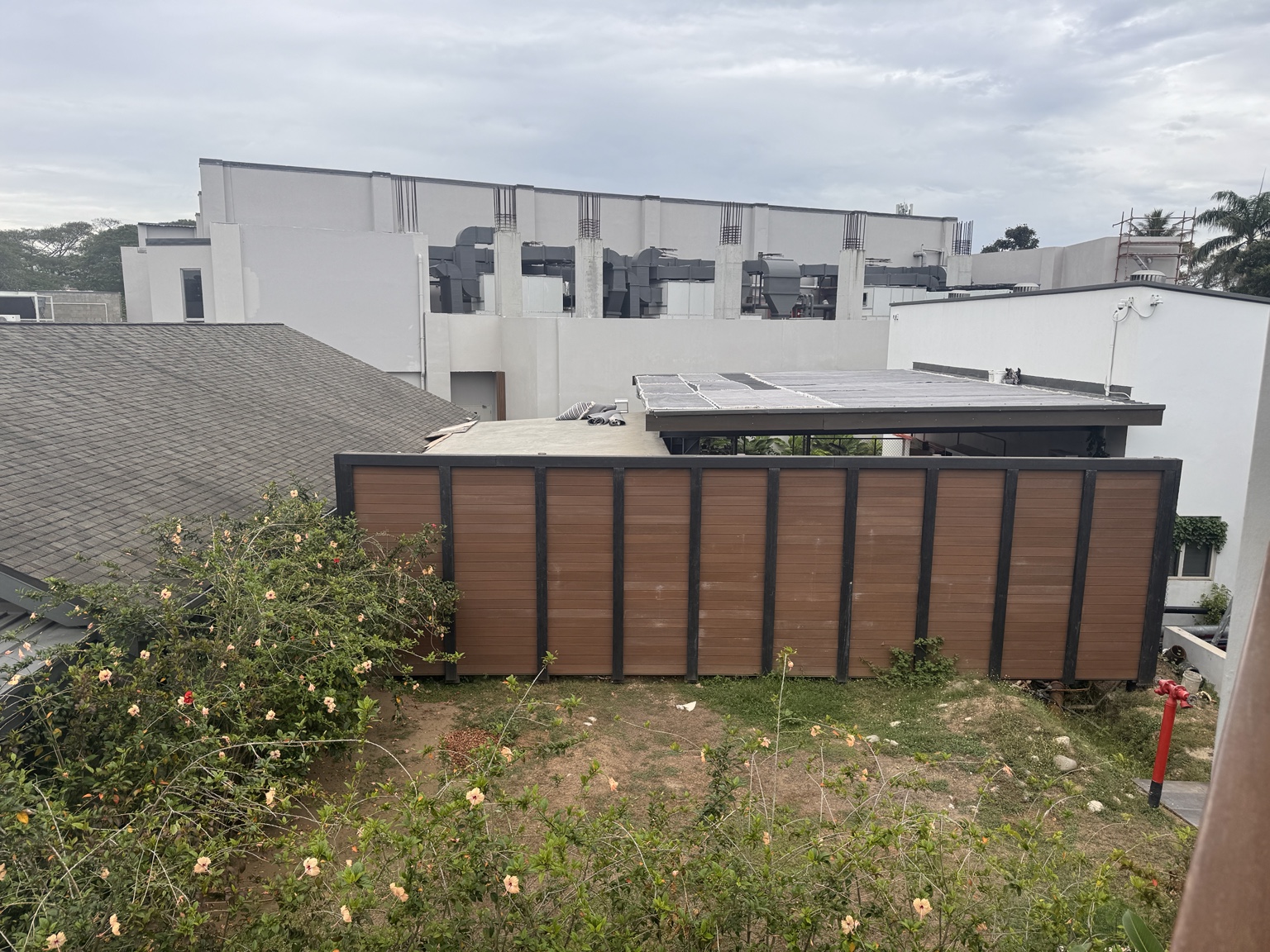 View from the upper-level room walkway across service roofs and exposed rooftop equipment