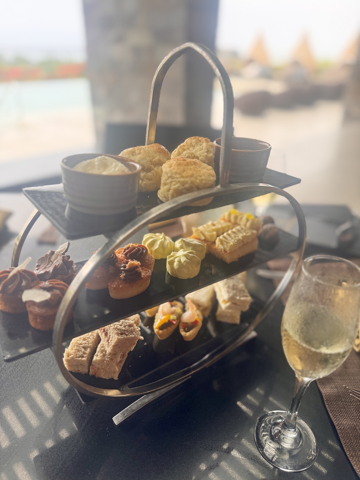 Tiered afternoon tea with scones, sandwiches and cakes beside the Club pool