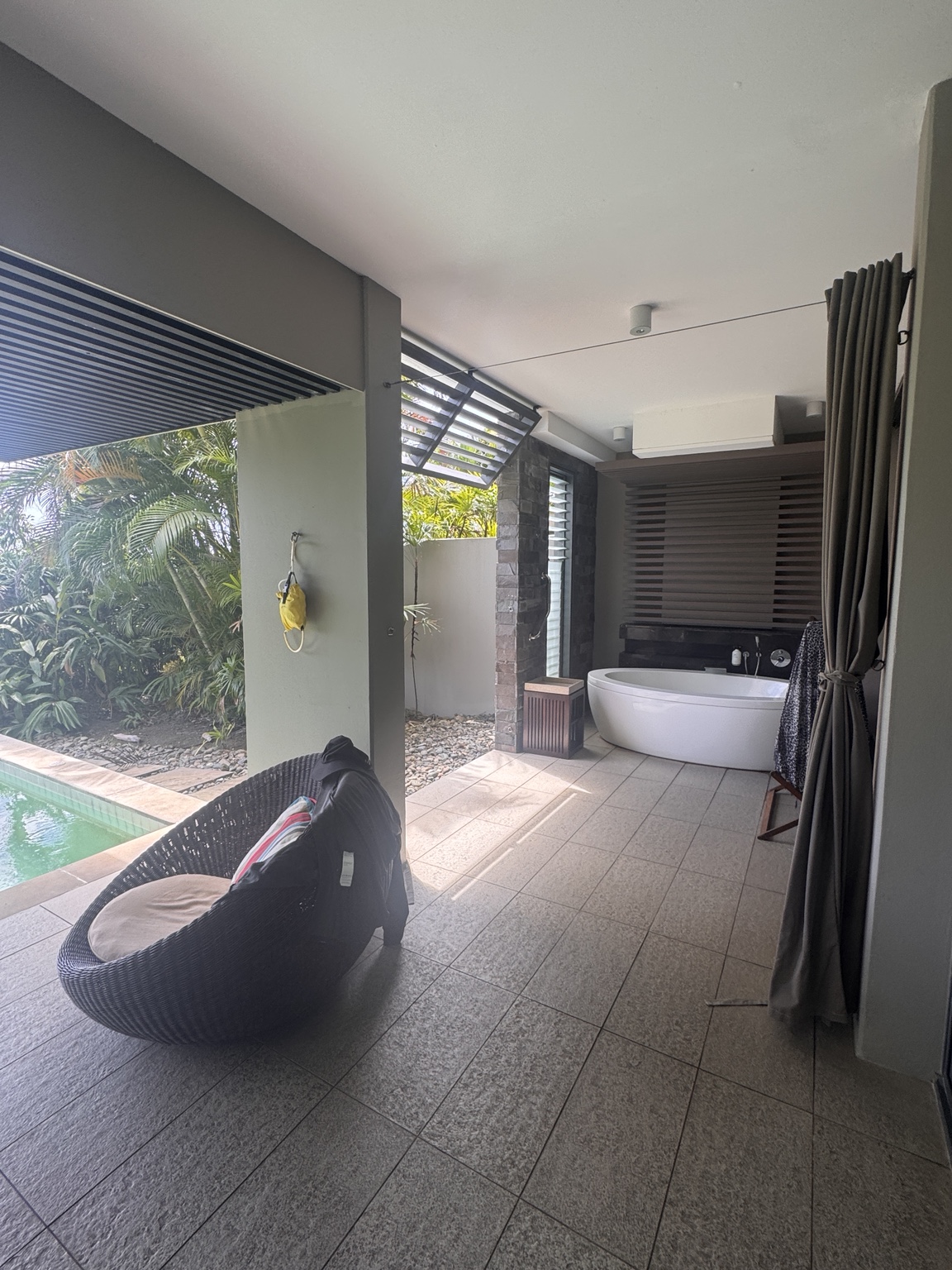 Outdoor bath beside the covered terrace with privacy curtains